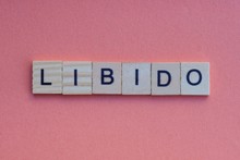 Word Libido From Small Gray Wooden Letters Lies On A Red Background