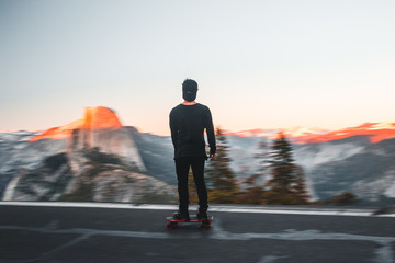 Wall Mural - rear view of man skateboarding on road