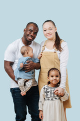 International family together. Parents and their cute children smiling at camera.