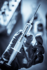 Hand holding a syringe with the coronavirus COVID-19 vaccine