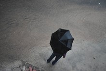 High Angle View Of Man With Umbrella Standing On Road During Rainy Season