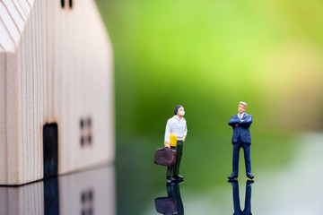  Miniature people : Businessmen standing with a man who do not have money to pay rent with blurred background. Property Business, financial and Strategy Planning and protection concept.