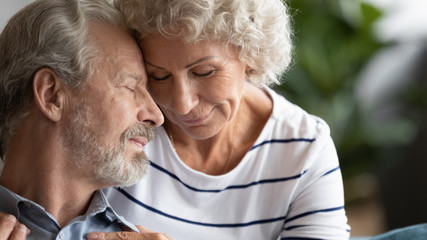 Happy mature couple in love enjoying tender moment close up, older wife and husband with closed eyes touching foreheads, good trusted family relationship, expressing care, peaceful and calm