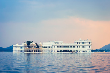 Fototapete - Romantic luxury India travel tourism - Lake Palace (Jag Niwas) complex on Lake Pichola on sunset with dramatic sky, Udaipur, Rajasthan, India