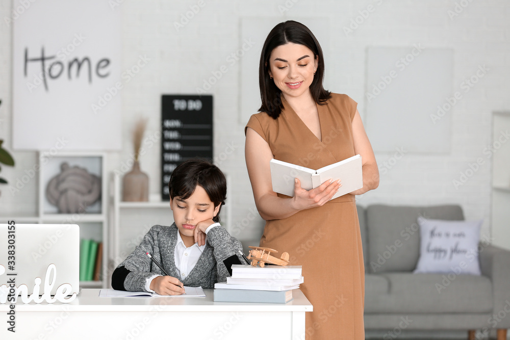Little boy with his mother doing homework in room