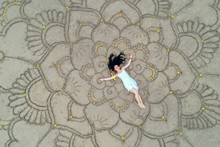 A Large Mandala Painted On The Sand On The Ocean With A Girl In The Middle Boho Style.