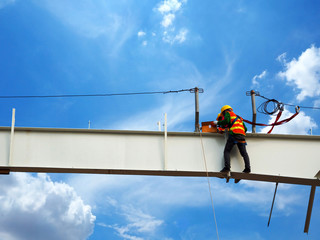 Man Working on the Working at height on construction site with blue sky