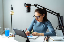 Online Content Creator Vlogger. A Young Women Blogger With Glasses Removes The Content For The Blog, Training Courses. The Concept Of Online Learning To Draw On Walercolor.