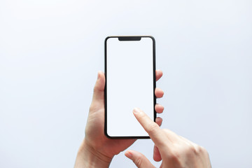 Smartphone mockup. Close up hand holding black phone white screen. Isolated on white background. Mobile phone frameless design concept.