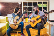 © Mediteraneo - Guitar teacher teaching the girl at home.