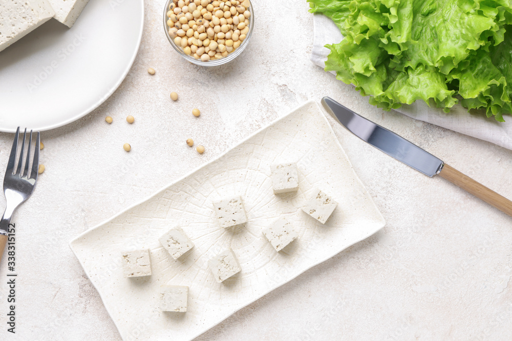 Plate with tasty tofu cheese on white background