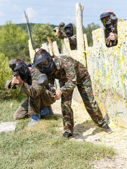 Wall Mural - Female paintball player aiming in shootout