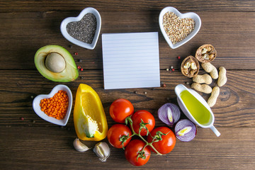 Keto diet. Vegetables and nuts are lined in the shape of a circle, inside a sticker with place for text. Top views clear space