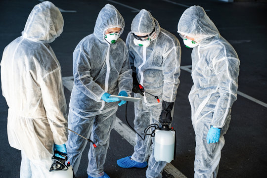 Team of healthcare workers wearing hazmat suits working together to control an outbreak in the city