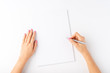 © One Pixel Studio - Woman’s hands writing with pen over blank paper isolated on white background. Top view