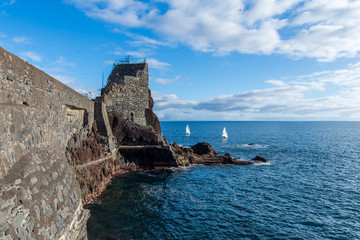 Sailboats on the sea outside the old part of Funchal harbor.