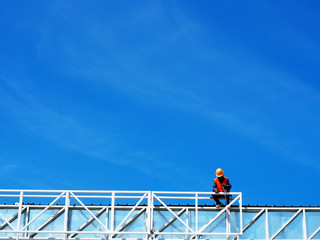 Man Working on the Working at height on construction site with blue sky