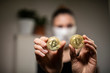 © Yehuda - Woman holding bitcoins during corona time.