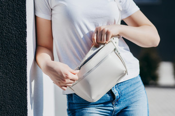 Young model girl in white t-shirt and glasses with waist bag