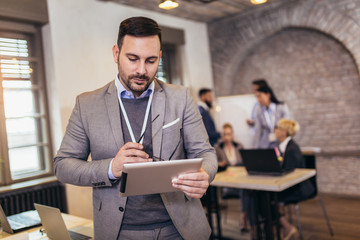 Wall Mural - Businessman using his digital tablet in the office