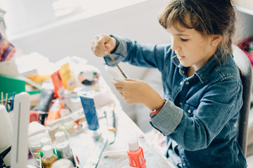 Wall Mural - portrait of young child girl crafting at home