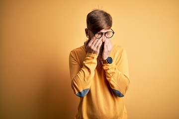 Canvas Print - Handsome Irish redhead man with beard wearing glasses over yellow isolated background rubbing eyes for fatigue and headache, sleepy and tired expression. Vision problem