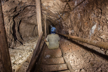 Miner explorer sitting on the stairs in underground mine