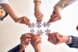 © Krakenimages.com - Group of business workers with hands together connecting pieces of puzzle at the office