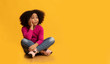 © Prostock-studio - Pensive little girl sitting on floor over yellow background and thinking