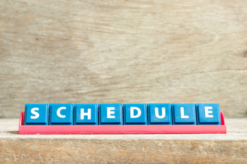 Canvas Print - Tile letter on red rack in word schedule on wood background