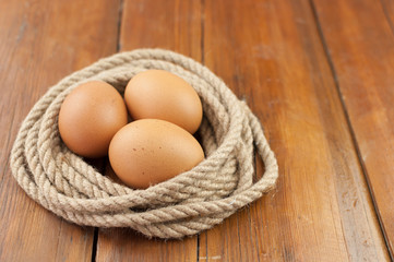 Brown three egg in a nest of twine for Happy Easter.