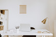 Modern minimal interior design concept. Bright Scandinavian home office desk table workspace with laptop, lamp, books. Business study cabinet. Girl boss studio concept.