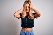 © Krakenimages.com - Young beautiful blonde woman wearing casual t-shirt standing over isolated white background suffering from headache desperate and stressed because pain and migraine. Hands on head.