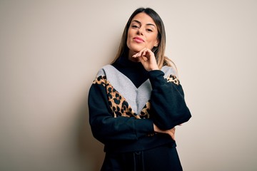 Poster - Young beautiful woman wearing casual sweatshirt standing over isolated white background with hand on chin thinking about question, pensive expression. Smiling and thoughtful face. Doubt concept.