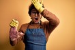 © Krakenimages.com - Young handsome butcher man holding meet steak standing over isolated yellow background surprised with hand on head for mistake, remember error. Forgot, bad memory concept.