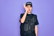 © Krakenimages.com - Young police woman wearing security bulletproof vest uniform over purple background doing ok gesture shocked with surprised face, eye looking through fingers. Unbelieving expression.