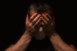 © Marina P. - Man with white medical mask on his face, holding his head with his hands, alone and scared in the dark