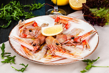 Wall Mural - Seafood. Langoustine, scampi or Norway lobster with lemon on white plate.