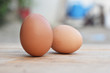 © nawin - Two brown chicken eggs on a wooden table soft focus.