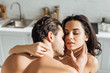 Passionate woman and man with closed eyes hugging in kitchen