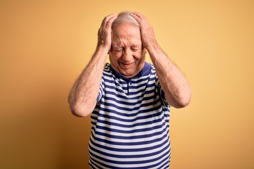 Poster - Grey haired senior man wearing casual navy striped t-shirt standing over yellow background suffering from headache desperate and stressed because pain and migraine. Hands on head.