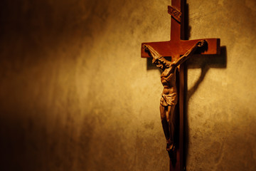 The Crucifix of Jesus Christ hanged on gray concrete wall background with copy space for your text, christian background