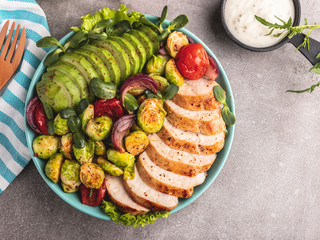 Wall Mural - roasted sliced chicken fillet with brussels sprouts, tomatoes and herbs on a plate healthy food