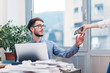 © Suteren Studio - Young businessman in office working on laptop. Woman coworker handing phone to young intern for a quick call.