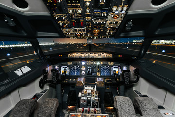 Full view of cockpit modern Boeing aircraft before take-off. Airplane is ready to fly. Night shot in cabin. Safety flight