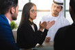 © Moez - Arab attractive businesswoman, teacher or mentor coach speaking to people, Arabic woman in glasses teaching audience at training seminar, female business leader speaker talking at meeting.