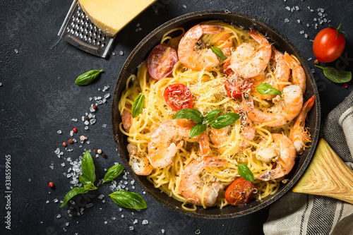 Fotografía Pasta seafood with shrimp on black table.