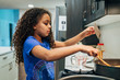 © Inti St. Clair - Girl cooking meal at stove in home kitchen