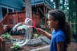 © Inti St. Clair - Girl blowing giant bubbles in the back yard of house