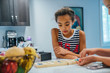 © Inti St. Clair - Girls playing game with marbles at kitchen counter
